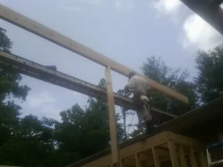 Carpenter setting a ridge beam over a new addition frame — Ice Dam Removal by Roofing Brothers in Laguna Hills