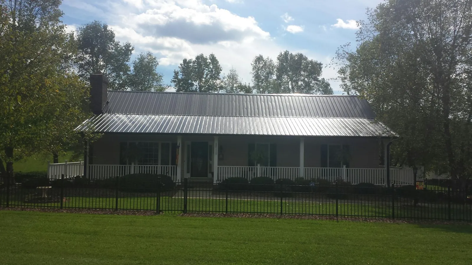 Gray metal roof on a brick ranch with a full width front porch — Gutter Guard Installation work by our crew in Laguna Hills